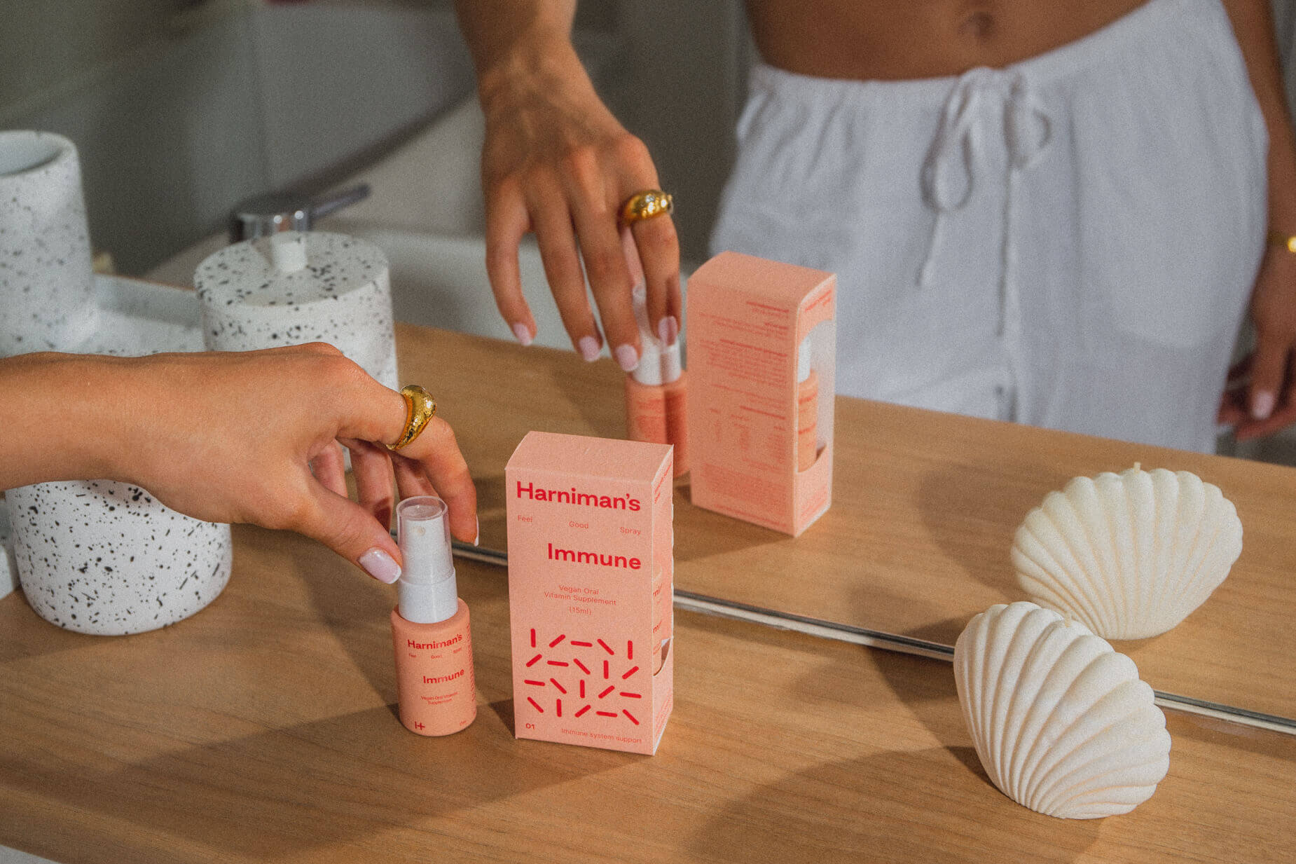 Woman's hand holding a bottle of Harniman's vitamin spray